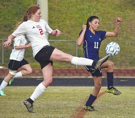 picture of player Mary Jo Lowe Kicking the ball in a game against Nount Airy